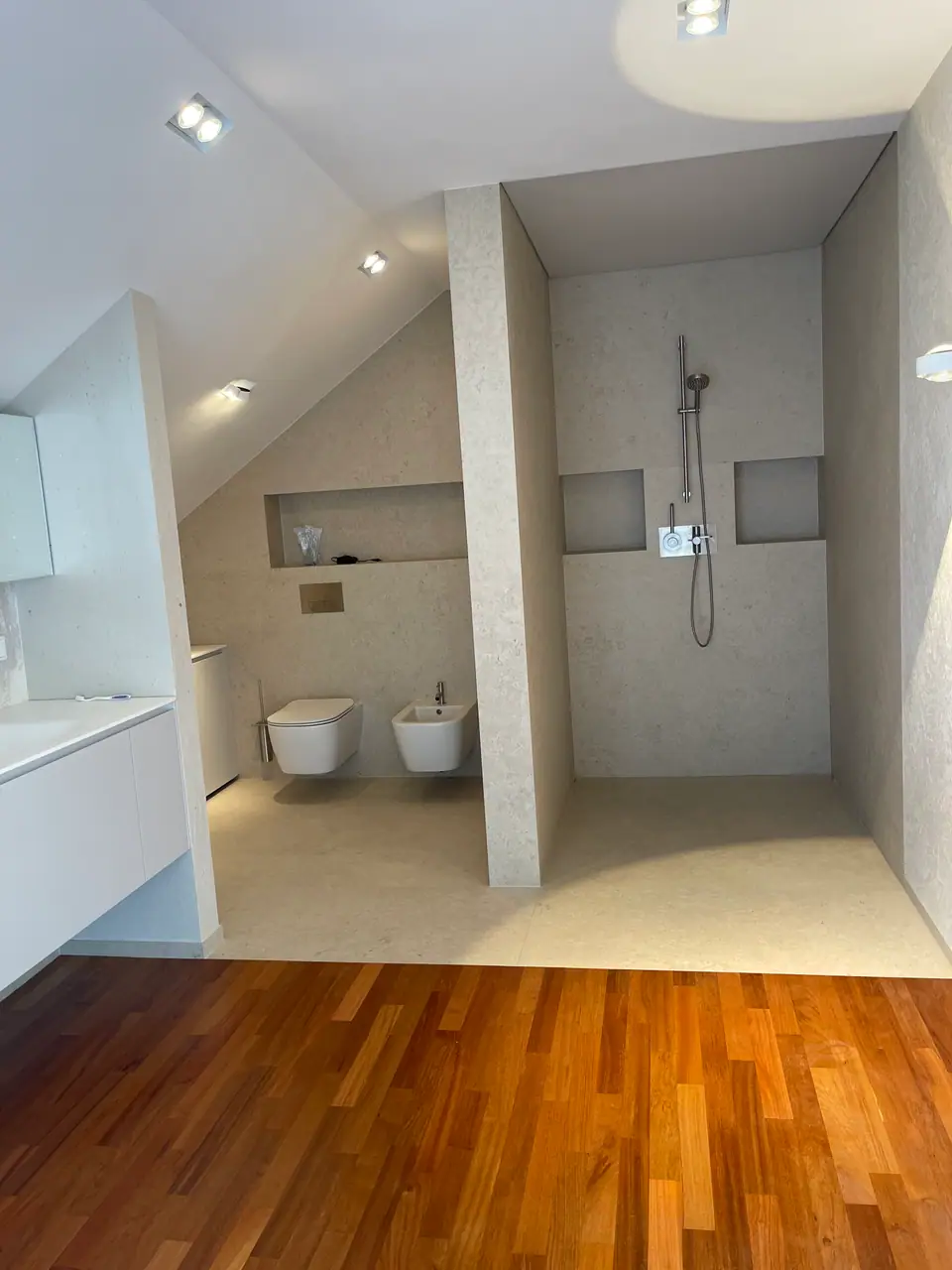 Badezimmer mit hellem Fliesenboden und Doussie-Parkett im Vordergrund.