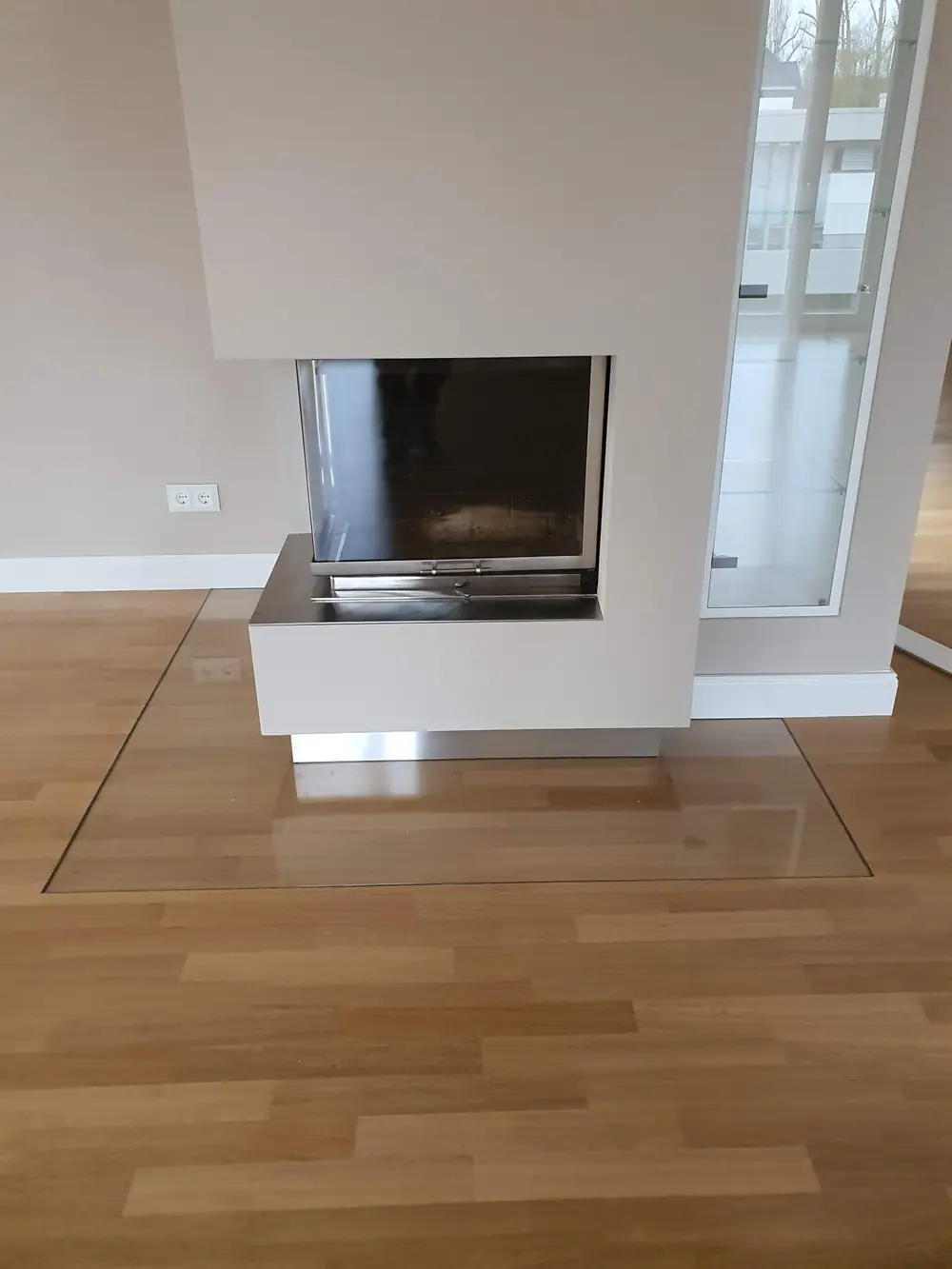 Parkett und Glasplatte vor dem Kamin
