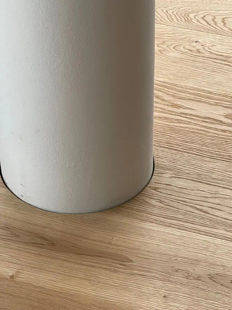 Nahaufnahme einer runden, verputzten Säule mit passgenau anschließenden Eichen-Landhausdielen.