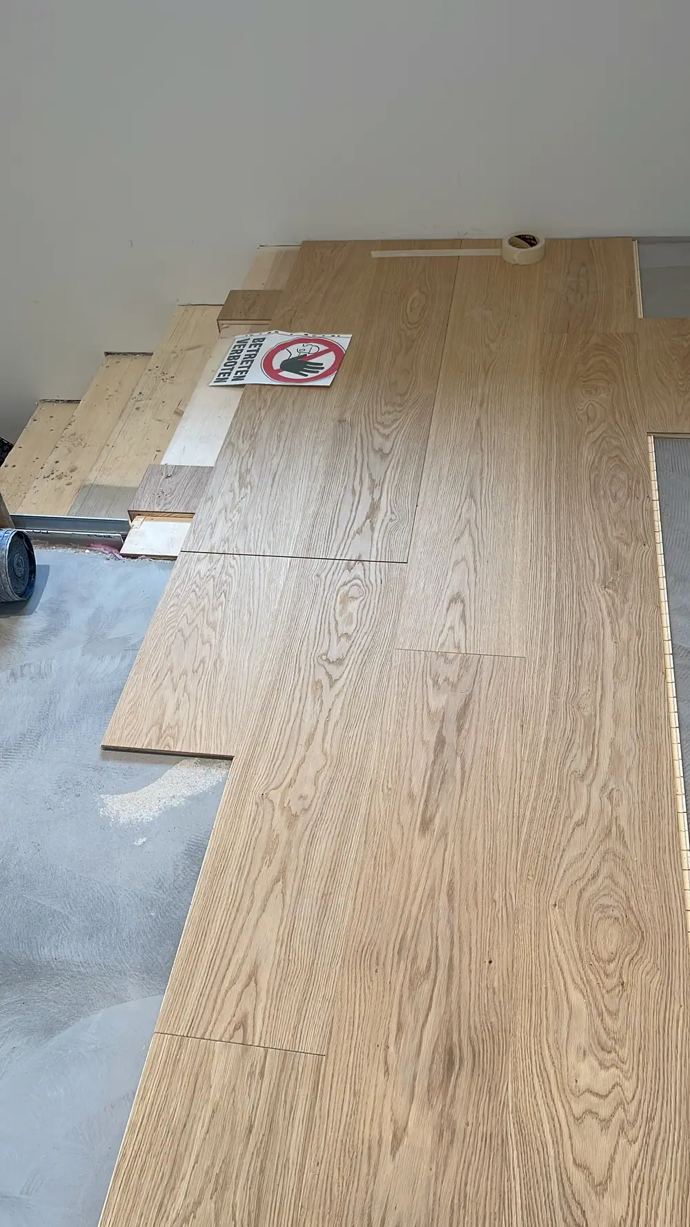 Landhausdielen aus Eiche während der Verlegung neben einer Treppe.
