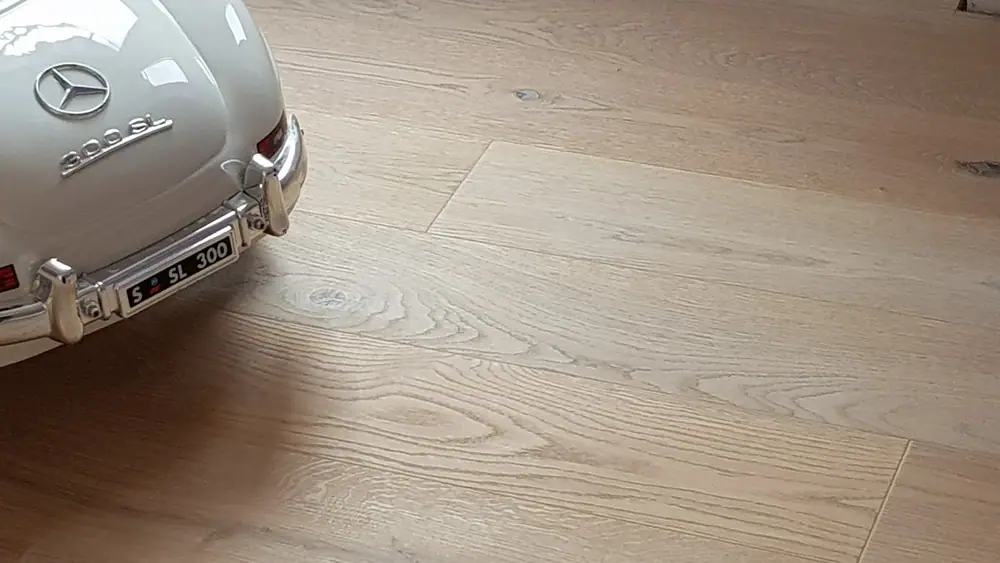 Die weiß geölte Maserung neben einem Spielzeugauto