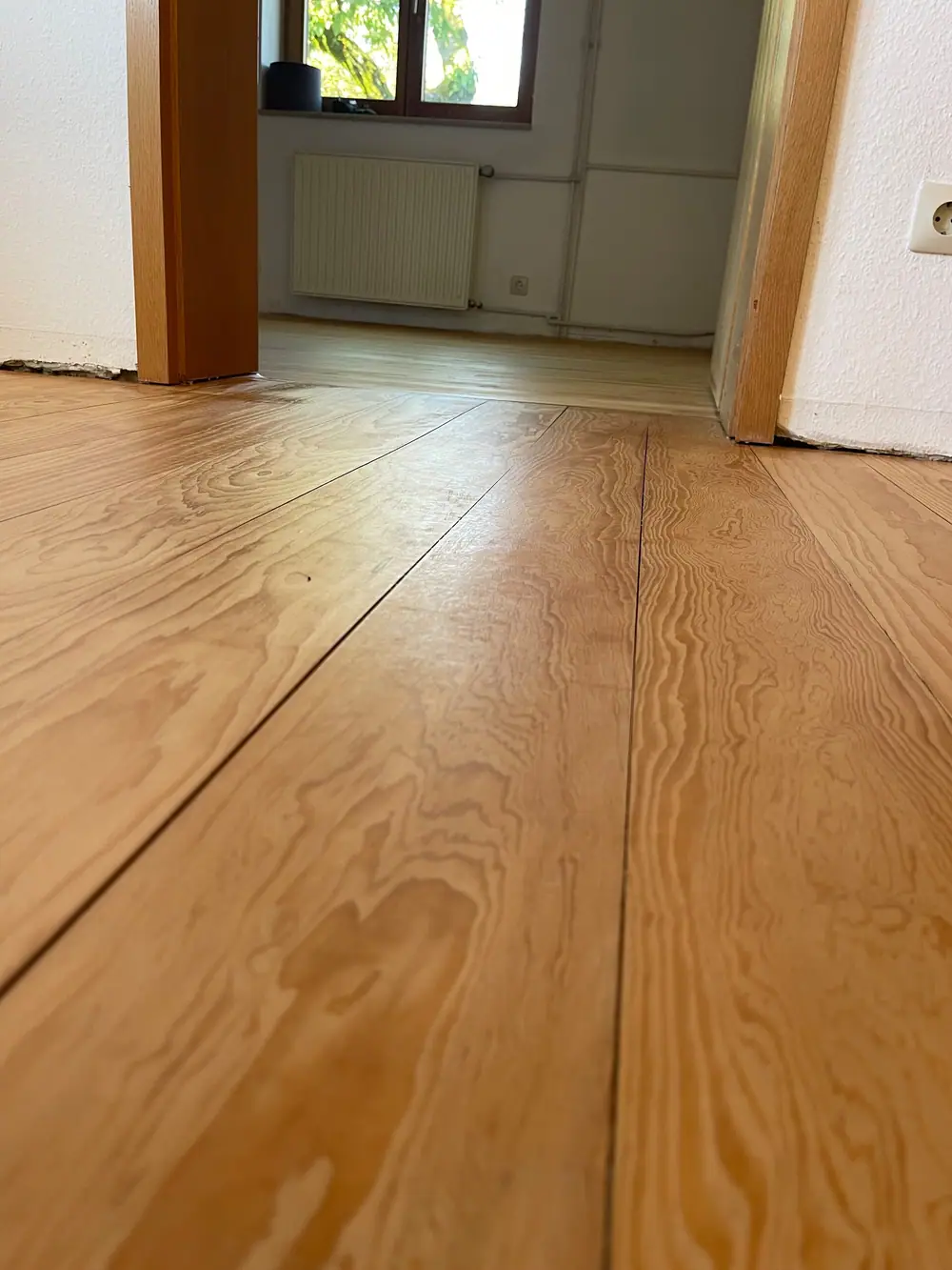 Nahansicht von breiten Holzdielen vor zwei Türdurchgängen mit sichtbarer Holzmaserung.