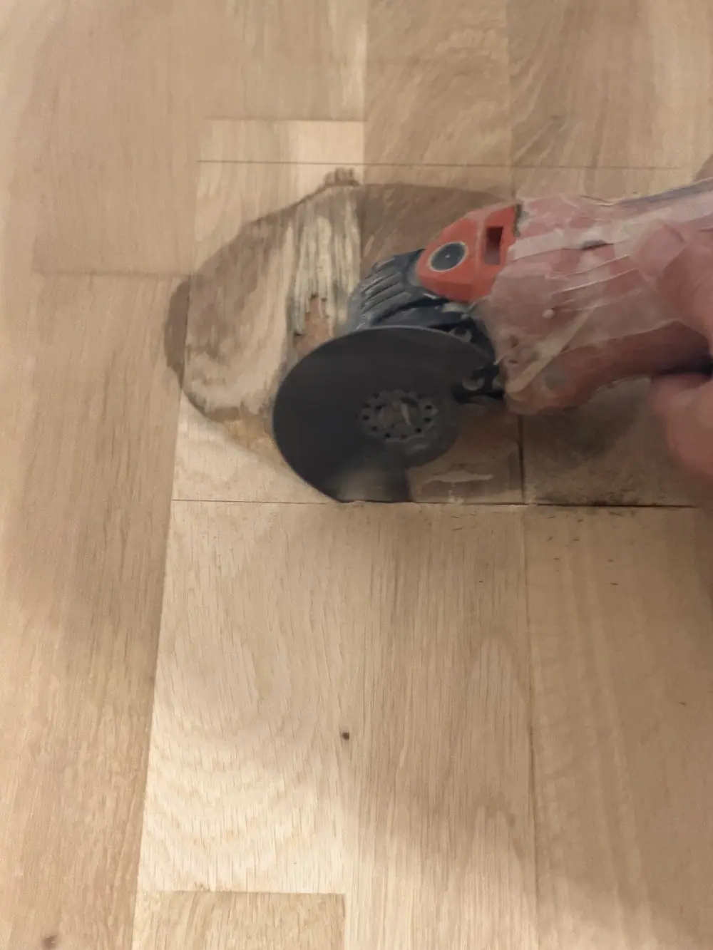 Unscharfe Nahaufnahme einer hellen Holzoberfläche mit einem teilweise sichtbaren Arbeitsgerät.
