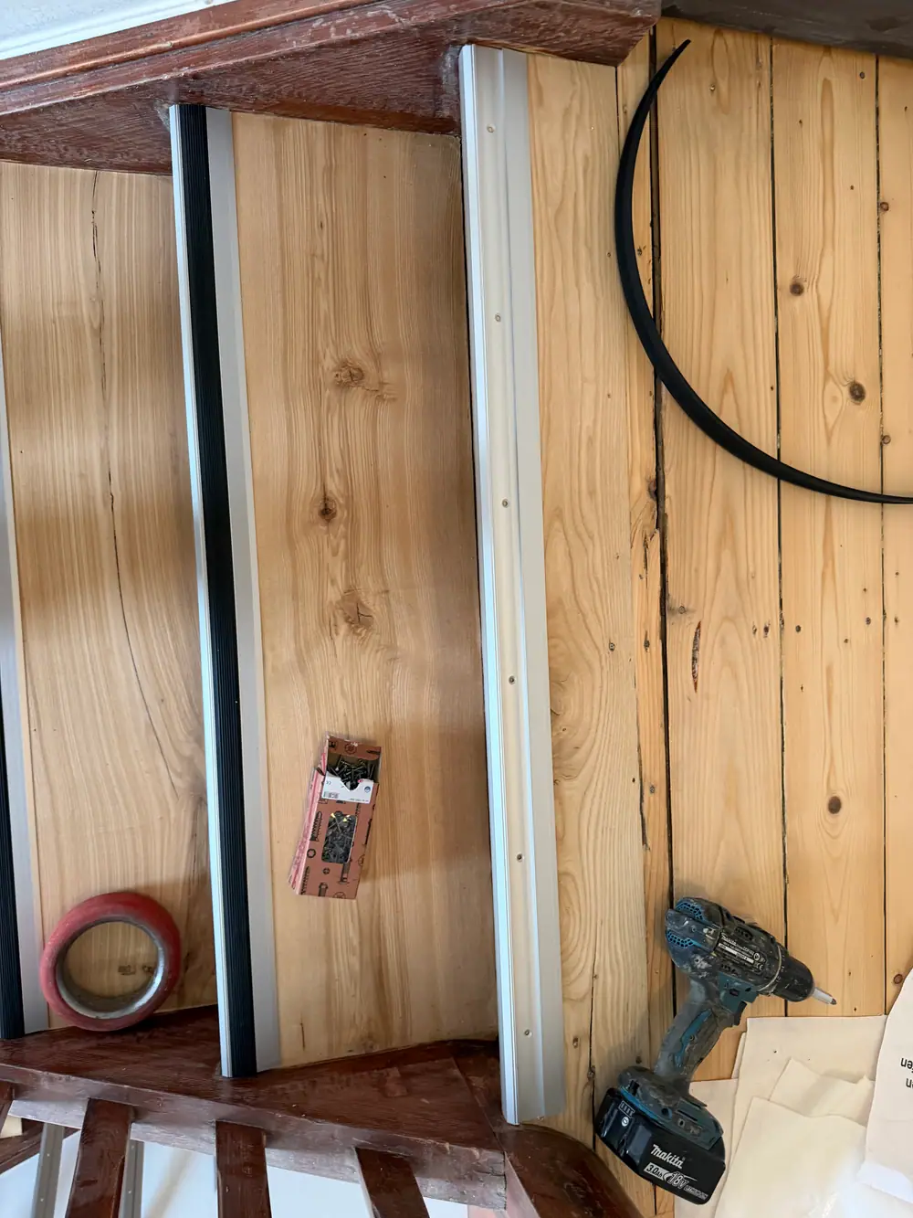 Nahaufnahme einer Holzstufe mit einem silberfarbenen Aluminiumprofil und schwarzer geriffelter Gummieinlage an der Stufenkante.