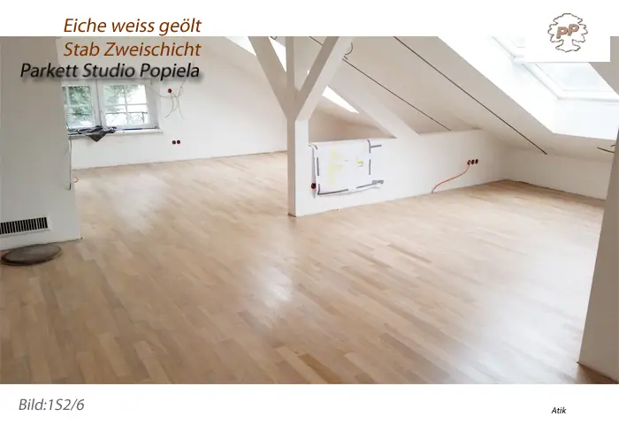 Die helle Eichenfläche zwischen weißen Wänden und Balken